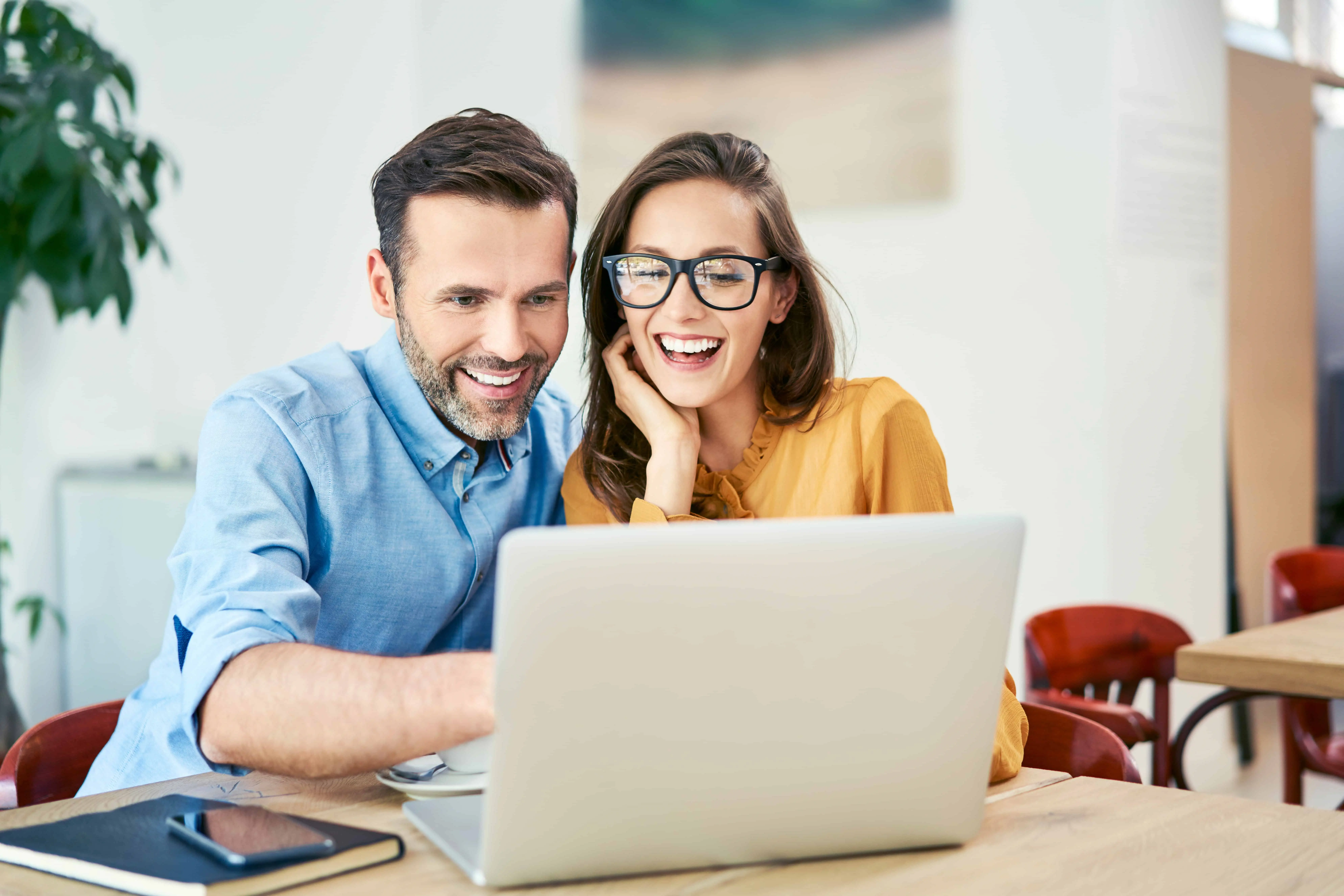 A couple looking at a laptop reviewing which Blackhawk Bank & Trust checking account is the correct fit for them.